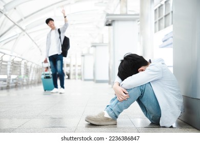 Asian boy sits crying on the skywalk connecting the walkway to the airport waiting for his father for a long time. Little boy kid is sitting alone in city. - Powered by Shutterstock