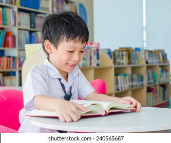 Asian Boy Student In Uniform Reading Book In School Library