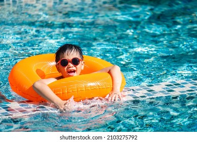 Asian boy swim at the swimming pool in summer - Shutterstock ID 2103275792