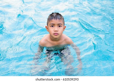 Asian Boy Swimming In The Outdoor Public Pool.Portrait Of Swimming Child With Goggles After Training In Water Pool.