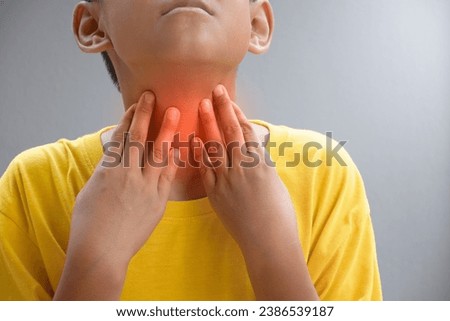 Asian boy touching the neck due to a sore throat or Itching in the throat causes of Irritation and infection in the respiratory tract and bacterial infection concept of medical and health care.