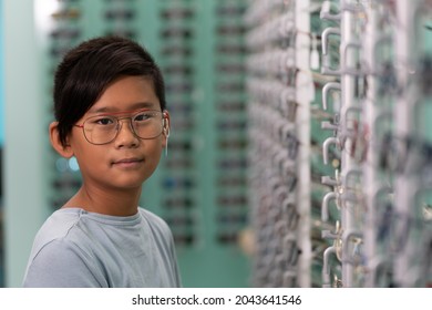 An Asian Boy Trying On Glasses In An Optician Store.