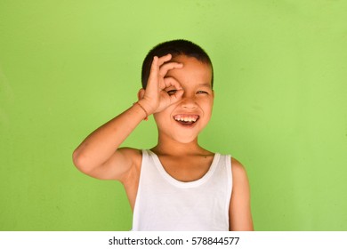 Asian boy using hand a circle around the eye.