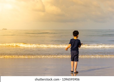 Asian boy walking on a beach in the morning