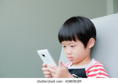 A Asian Boy Watching Smart Phone With Copyspace