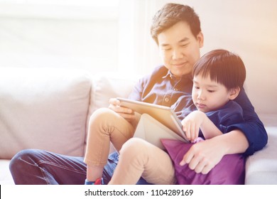 Asian Boy Is Watching A Tablet. Father Taught Social Learning From Around The World To His Son. Or What The Children Do Not Understand. It Is A Good Family Relationship. Father's Day Family Concept