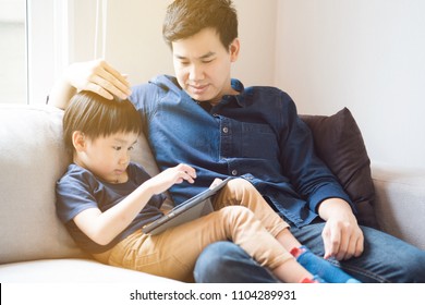 Asian Boy Is Watching A Tablet. Father Taught Social Learning From Around The World To His Son. Or What The Children Do Not Understand. It Is A Good Family Relationship. Father's Day Family Concept