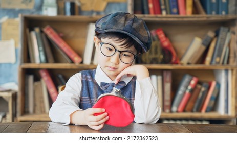 Asian boy watching a wallet in front of book shelf. - Shutterstock ID 2172362523