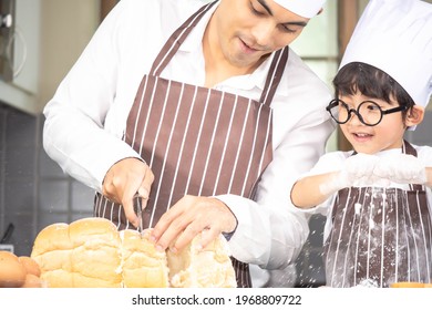 Asian Boy Wear Glasses Tease Dad Cooking With White Flour Kneading Bread Dough Teaches Children Practice Baking Ingredients Bread, Egg On Tableware In Kitchen Lifestyle Happy Learning Life With Family