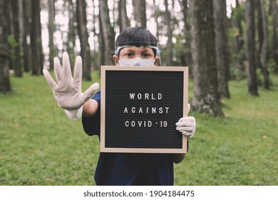 Asian Boy Wearing Face Masks And Rubber Hand Glove Standing With Stop Gesture In His Hand While Holding Quote On Letter Board Says World Against Covid 19