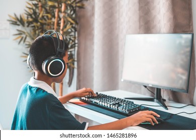 Asian boy wearing headphones playing computer games-image. - Shutterstock ID 1465281896