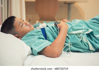 Asian Boy Wearing Sleep Apnea Diagnostic Medical Device Kit. Sleep Test Concept.