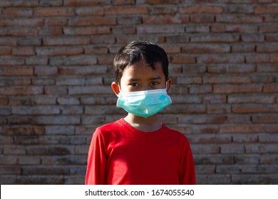An Asian boy wears a protective mask to stop the infection of COVID-19.