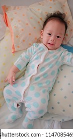 Asian Boy Worn Polkadot Suit Is Lying In The Bed.