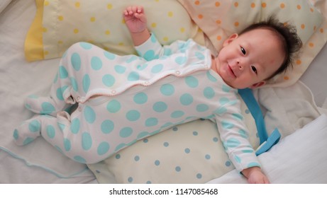 Asian Boy Worn Polkadot Suit Is Lying In The Bed.