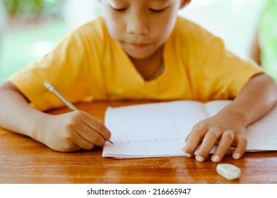 Asian Boy Writing English Alphabets.