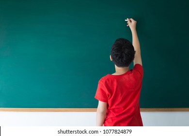 Asian Boy Writing On Empty Green Board In Class Room At School