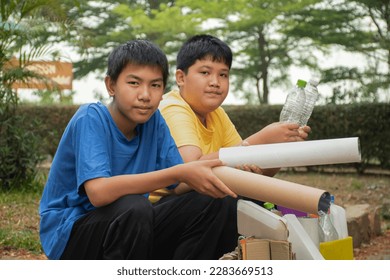 Asian boys in caucasian are separating garbages at the community's park, soft and selective focus, environment care, community service and summer vacation activities of teenagers concept. - Shutterstock ID 2283669513