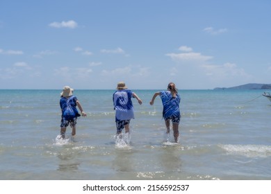 Asian Boys And Girls Run Into The Sea Excitedly Over The Summer Semester Holidays.