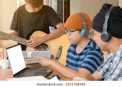 Asian boys wear beanie and headphones and learning music lesson on laptop in media library of their school, teens' lifestyle concept, new edited. - Powered by Shutterstock