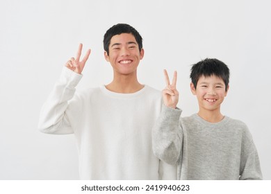 Asian brother peace sign gesture in white background