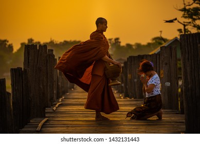 Asian buddha religion lady giving food to monk in early morning  to pay respect to Buddha is do good things for Buddhist at U-bein bridge , Myanmar. - Shutterstock ID 1432131443