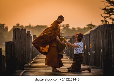 Asian buddha religion lady giving food to monk in early morning  to pay respect to Buddha is do good things for Buddhist at U-bein bridge , Myanmar. - Shutterstock ID 1432131446