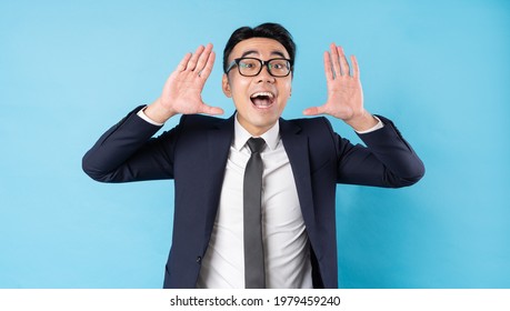 Asian Buisnessman Wearing Suit Shouting On Blue Background