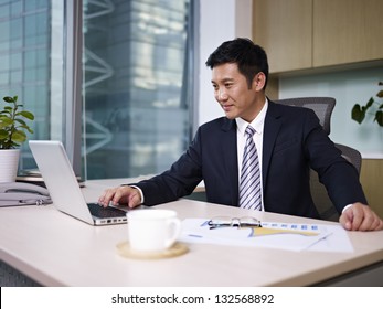 Asian Business Executive Working In Office.