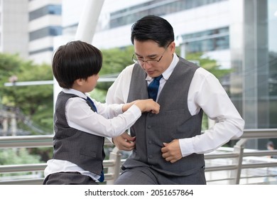 Asian Business Father And Son Confidence Child Want To Be Like A His Dad Parent And Young Boy Standing In City With Cityscape Background. Father Checking Clothes For Son Business Concept.