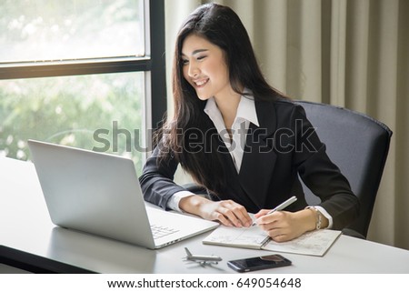 Asian business girl working in office with document and laptop