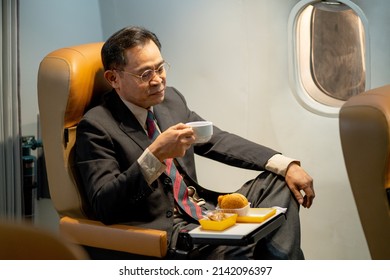 Asian Business Man Enjoy With Drinking Coffee Or Tea In Airplane During Go To Work In Other Town About New Project.