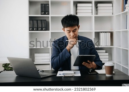 Asian business man executive manager looking at laptop watching online webinar training or having virtual meeting video conference doing market research working in office.
