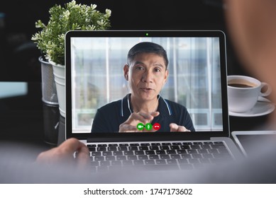 Asian Business Man Making Facetime Video Calling, Using Zoom Online Meeting Via Laptop Computer At Home Office, Teleconference, Video Conference, Work From Home, Telework, Teleconference Concept