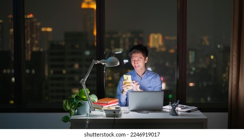 Asian business man sitting in office using laptop and smartphone for work - Powered by Shutterstock