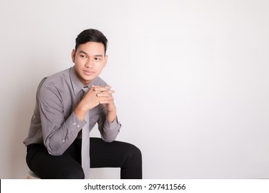 Asian Business Man Sitting On A Chair Over White Background