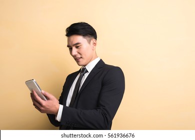 Asian Business Man Use Smart Phone, Closeup Portrait On Studio Yellow Background