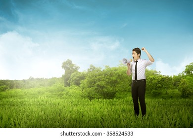 Asian  Business Man Yell Using Megaphone Over Woods Background