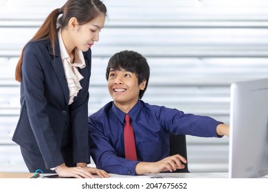 Asian Business Manger And His Female Staff Wearing Formal Suit Are Discussing Over The Annual Report In Computer In The Formal Business Office