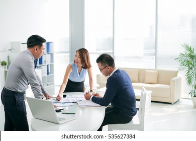 Asian Business Partners Working With Papers In The Office