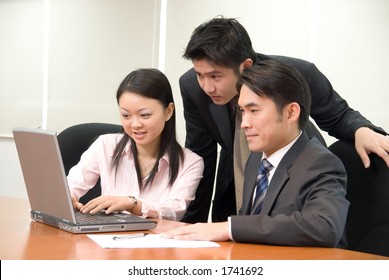 Asian Business People In Business Attire Working On A Notebook Pc