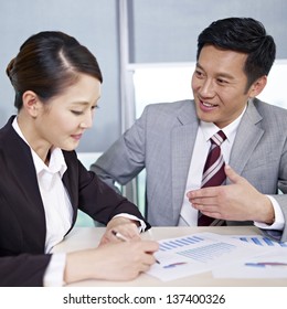 Asian Business People Discussing Business In Office.