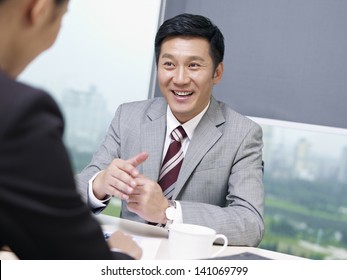 Asian Business People Discussing Business In Office.