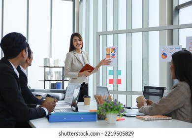 Asian business people meeting and talking in the room, businesswoman present in font of the board with discussion and participation - Shutterstock ID 2219505829