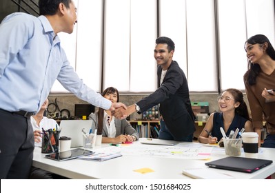 Asian Business People Smart Casual Wear Shaking Hands While Working In The Creative Office. Business Team Creative Concept