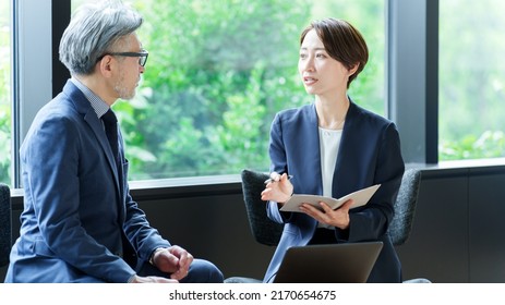 Asian Business People Talking In Office Lounge