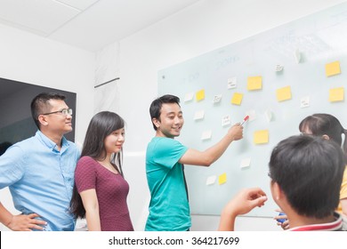 Asian Business People Team Drawing On White Wall Whiteboard With Sticky Notes Creative Real Office