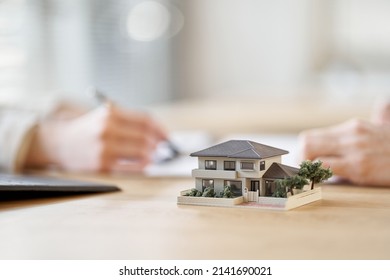 Asian business person having a meeting with the floor plan of real estate - Powered by Shutterstock