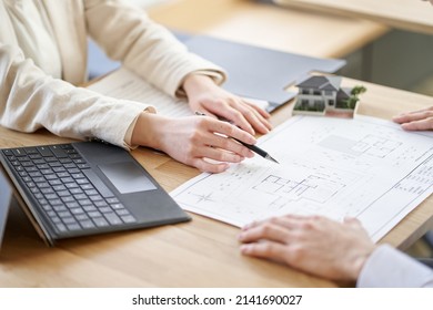 Asian business person having a meeting with the floor plan of real estate - Powered by Shutterstock