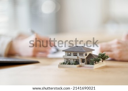 Asian business person having a meeting with the floor plan of real estate